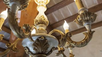 Un candelabro con múltiples luces similares a velas y elaborada ornamentación metálica.