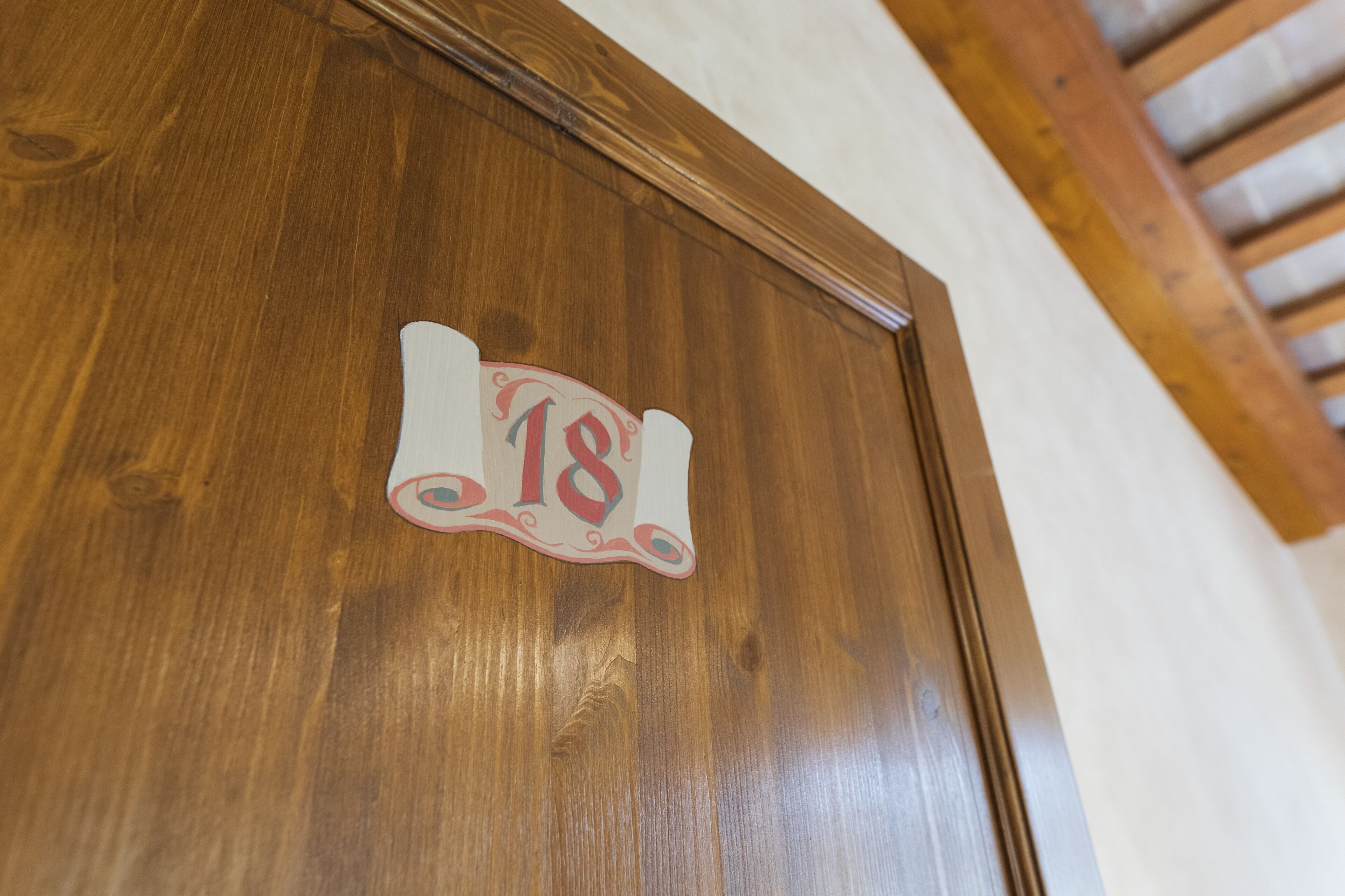 A wooden door with a number plaque.