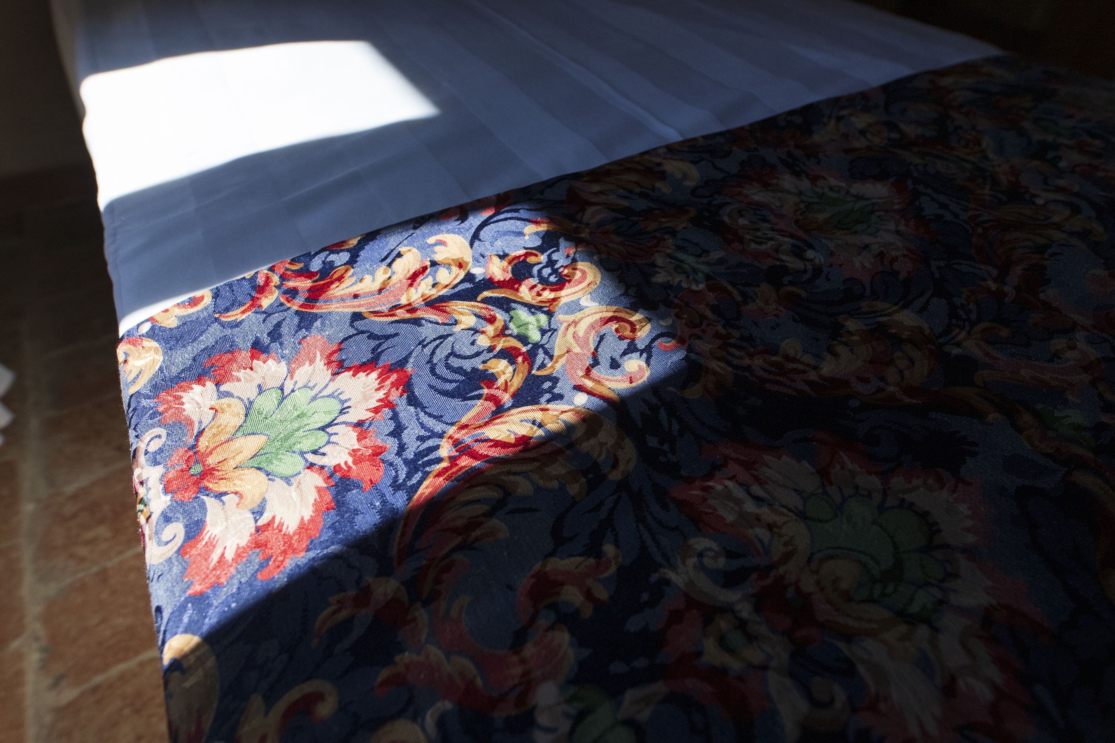 Tejido estampado, quizás un edredón o mantel, con un diseño floral.