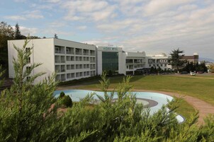 Un hotel moderno con un patio central y piscina.