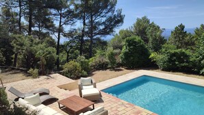 A rectangular swimming pool with a tiled deck, surrounded by lush greenery and tall trees. - Villa in Provence's sky - 300m from center - Private pool and panoramic view (Tourtour)