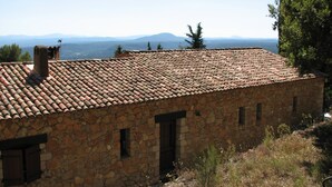 A stone building with a tiled roof, a chimney, and a view of distant mountains. - Villa in Provence's sky - 300m from center - Private pool and panoramic view (Tourtour)