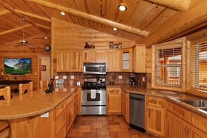 Una cocina con armarios de madera, electrodomésticos de acero inoxidable y una isla grande.