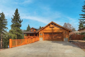 A two-story log cabin with a garage and a covered porch. - Bear Pause By Destination Big Bear: Walking Distance to the Lake! Castle Glen Estates Log Cabin Home! PET FRIENDLY! Fully Fenced! Pool Table! HOT TUB! Boarders Eagle Preserve! (Big Bear Lake)