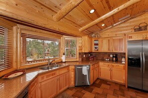 Een keuken met houten kastjes, een roestvrijstalen koelkast en een vaatwasser.