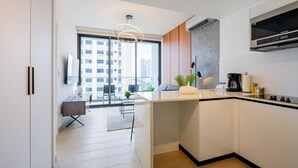 Une cuisine moderne dotée d’une grande fenêtre, d’un coin repas et offrant une vue sur la ville.