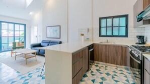 A modern kitchen with a central island, wooden cabinets, and a tiled floor. - w* | Spacious 1BR in Santa Ana (Panamá)