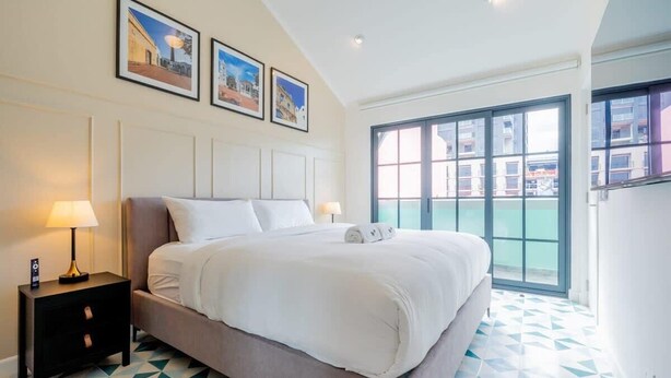 A hotel room with a large bed, a nightstand, and a window with a view of buildings. - w* | Spacious 1BR in Santa Ana (Panamá)