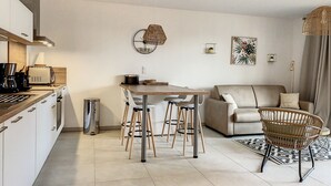 Eine moderne Küche mit Essbereich, einer Couch und einem Korbstuhl.