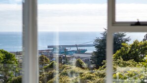 A view of a port with a large cargo ship, surrounded by greenery and a clear sky. - Sea You Soon: Views, Parking & WiFi (Montello)