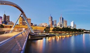 A city skyline with modern buildings and a bridge with a unique arch design. - A Chic 2BR Apt Right Next to Melbourne Central (Melbourne)