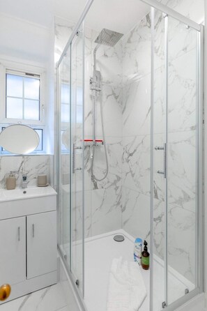 Apartamento básico | Banheiro | Chuveiro, toalhas de banho, sabonete, shampoo
