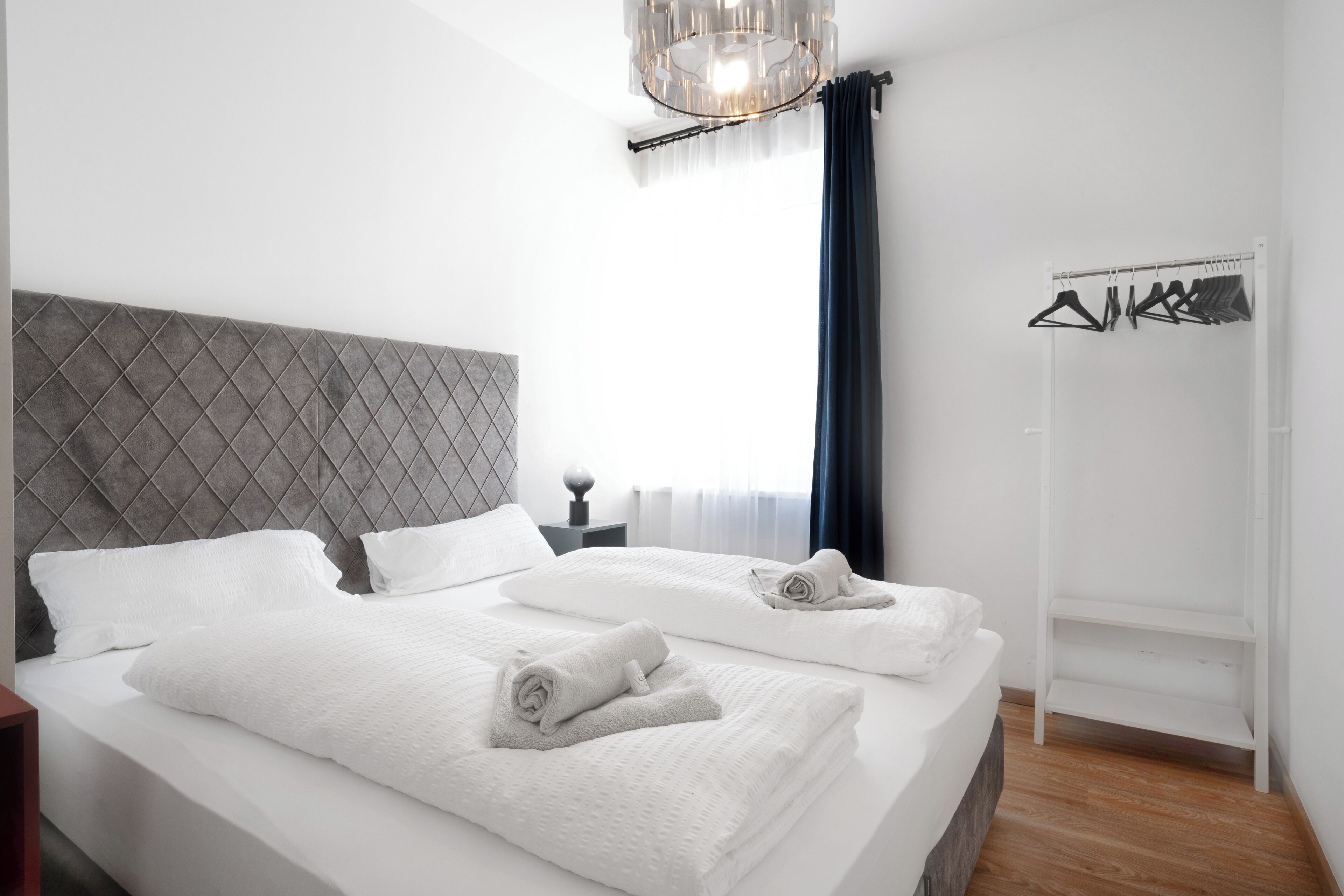 Ein Hotelzimmer mit einem großen Bett, einem Schrank und einer Kleiderstange.