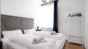 Ein Hotelzimmer mit einem großen Bett, einem Schrank und einer Kleiderstange.