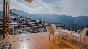 A balcony with a view of snow-covered mountains and a traditional village. - aMALA Villa - Six Bedroom Luxurious Villa with Himalayan View (Kaudia Range)