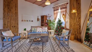 A cozy living room with a sofa, chairs, a coffee table, and a Christmas tree. - Unique Three bedroom with three Bathroom House in An Bang  (Thành phố Hội An)