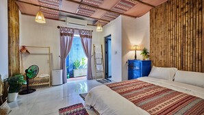 A bedroom with a large bed, a fan, a blue cabinet, and a view of the outdoors. - Unique Three bedroom with three Bathroom House in An Bang  (Thành phố Hội An)