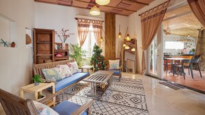 A cozy living room with a sofa, coffee table, and a Christmas tree. - Unique Three bedroom with three Bathroom House in An Bang  (Thành phố Hội An)
