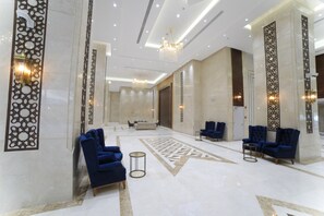 A spacious lobby with high ceilings, chandeliers, and blue upholstered chairs. - TIME Ruba Hotel & Suites (Makkah)