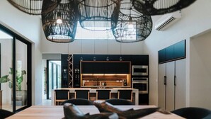 A modern kitchen with a central island, overhead lighting, and built-in appliances. - Avara House (Reserva de Golf, Hacienda Pinilla)