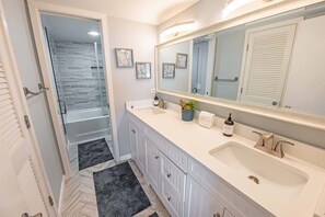 A modern bathroom with a large mirror, two sinks, and a shower area. - 3BR Pools, Direct Ocean Front, Ocean Creek, Views! (North Myrtle Beach)