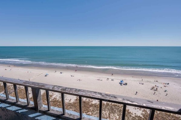 A beach with a clear view of the ocean and a railing in the foreground. - Amazing Views, Coastal Paradise Experience! (Myrtle Beach)