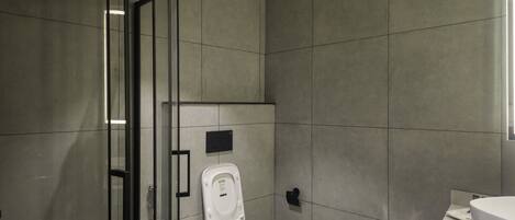 Un baño moderno con cabina de ducha de vidrio, inodoro y lavamanos.