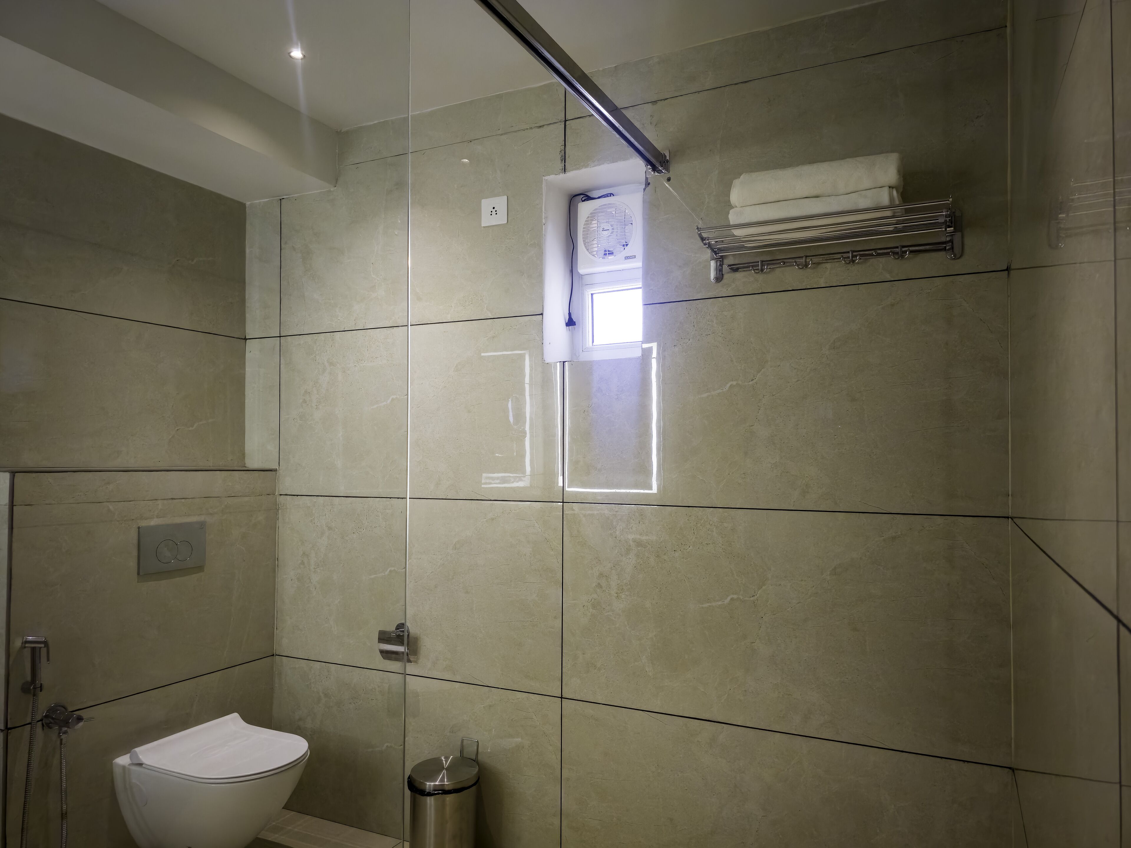 Un baño moderno con ducha, inodoro y toallero.