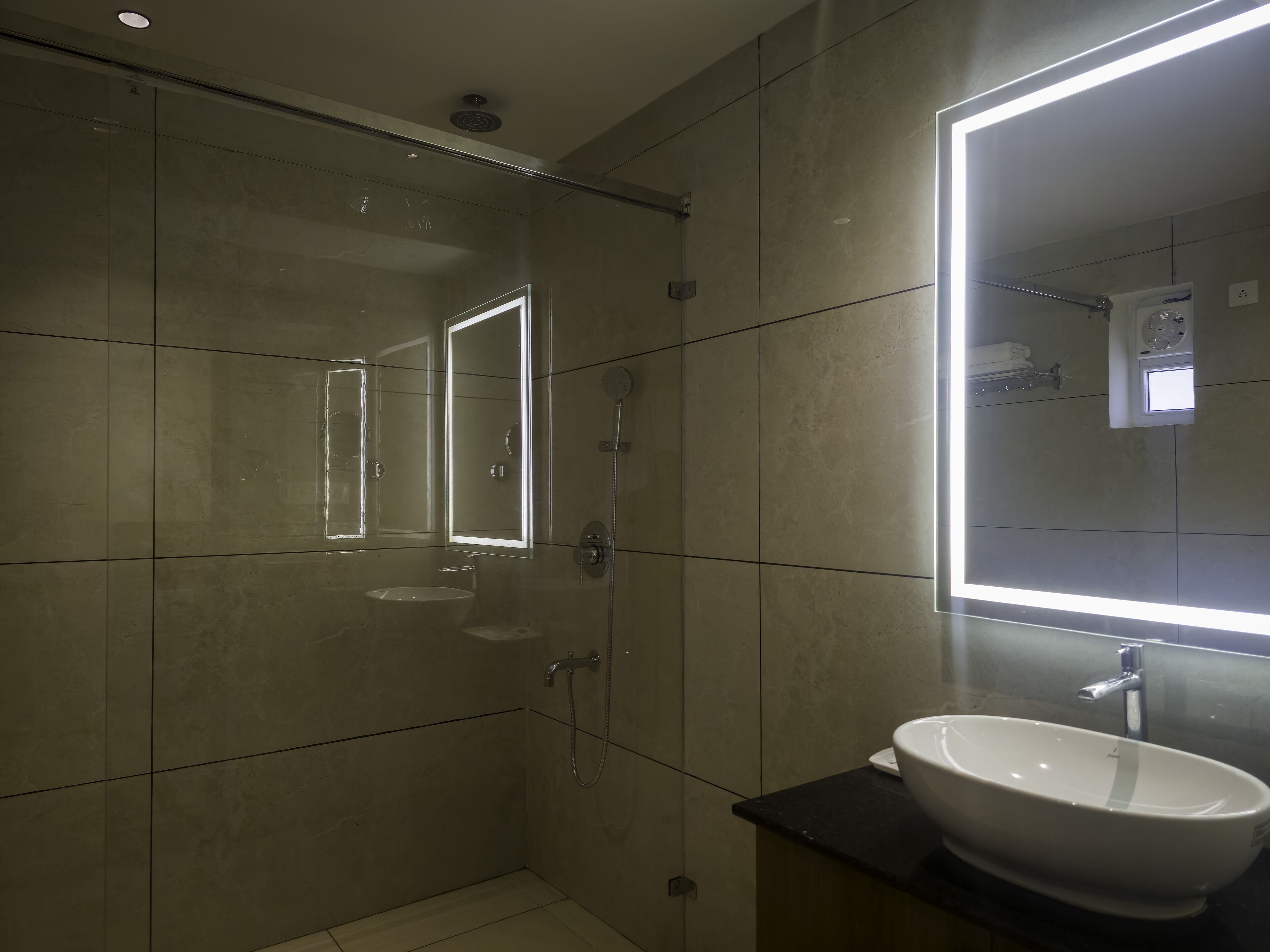 Ein modernes Badezimmer mit großem Spiegel, Waschbecken und Dusche.