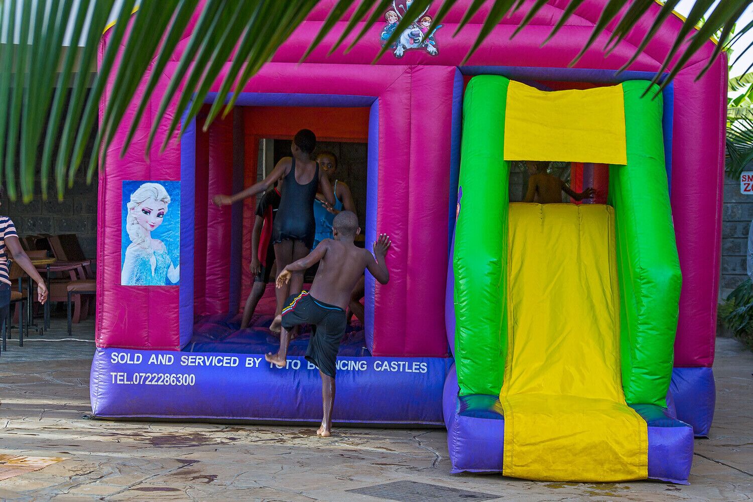 A colorful inflatable bounce castle with a cartoon character on the side.