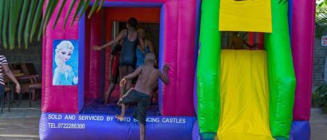 A colorful inflatable bounce castle with a cartoon character on the side.