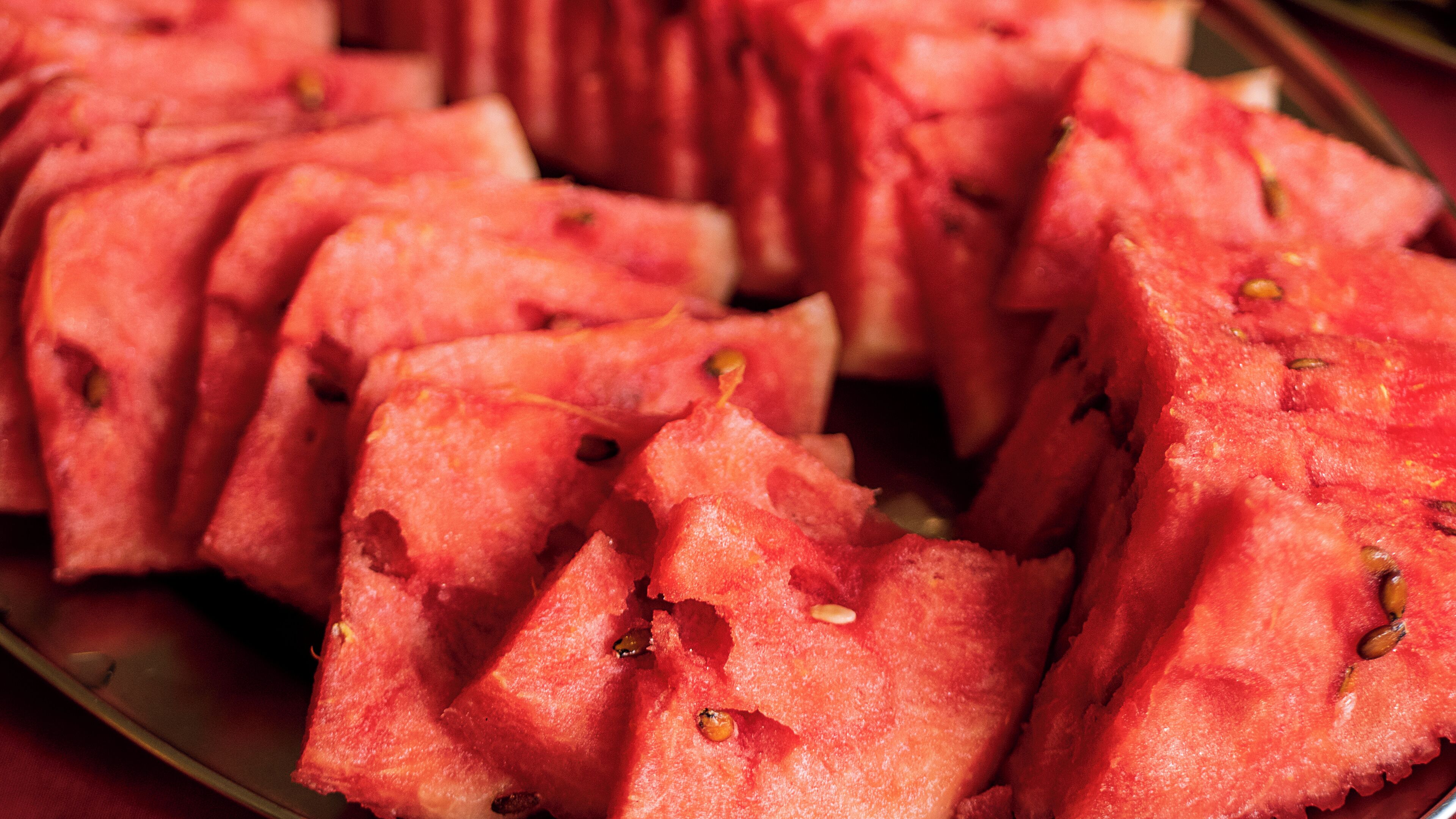 A plate of watermelon slices with seeds.
