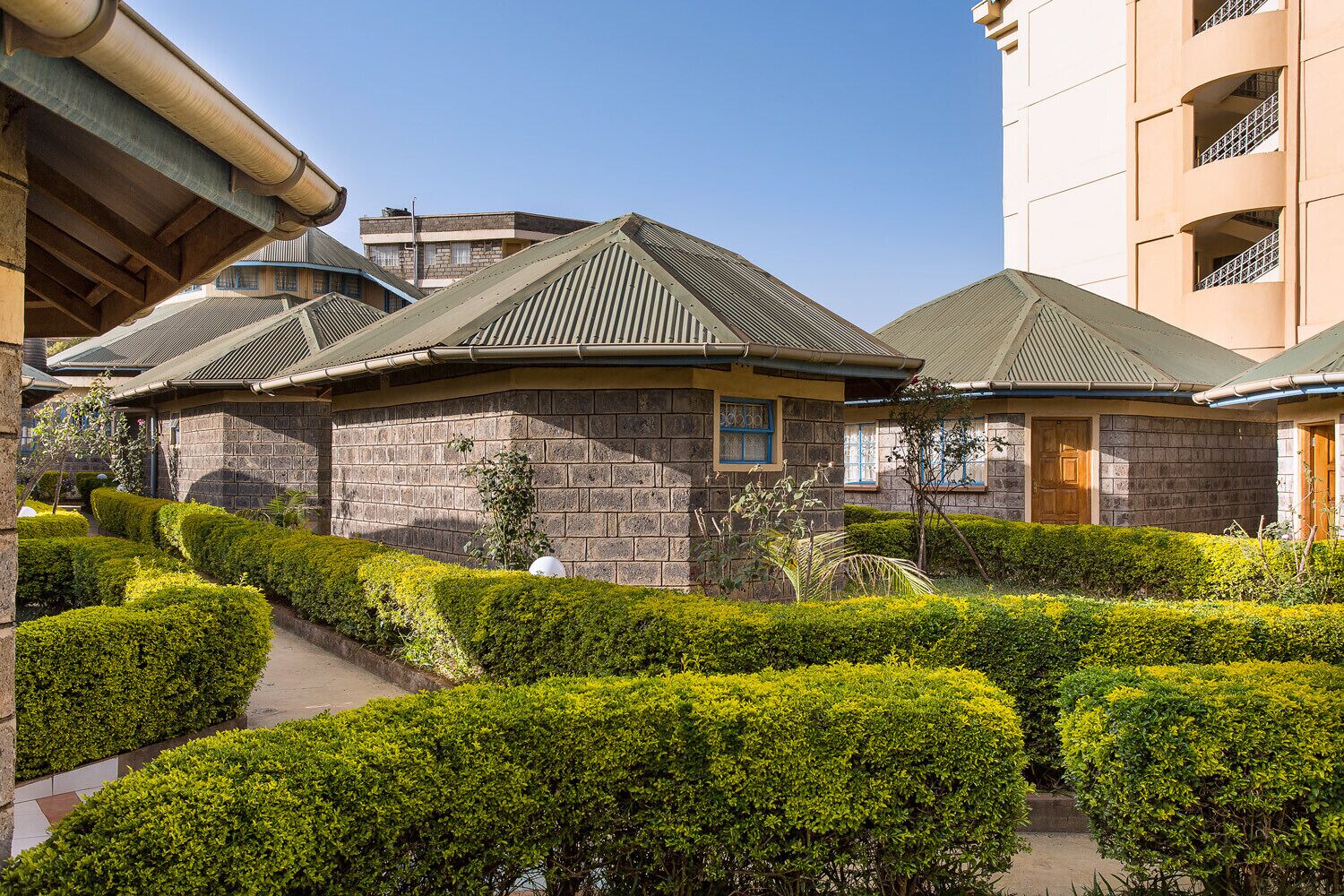 A traditional Japanese-style building with a stone facade, a tiled roof, and a well-maintained garden with neatly trimmed bushes.