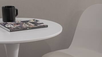 A white table with a black mug and a magazine.