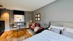 A modern bedroom with a large bed, a desk, and a chair. - Premium Apartment an der Stadtmauer im OG (Paderborn)