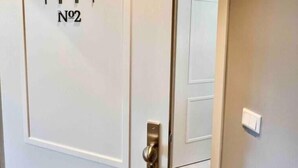 A white door with a door number sign and a modern door handle. - Premium Apartment an der Stadtmauer im OG (Paderborn)