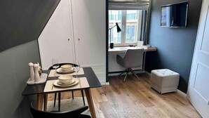 Una cocina moderna con comedor, piso de madera y vistas a la ciudad desde una ventana.