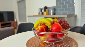 A bowl of fruit on a table in a modern kitchen with a clock on the wall. - 50 Queens Road Apartment 3 (Reading)