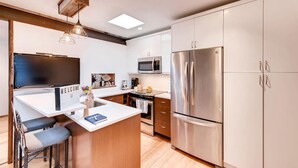 A modern kitchen with a central island, stainless steel appliances, and a welcoming 'WELCOME' sign. - Newly Renovated Condo + Pool: Minutes to Downtown (Nashville)