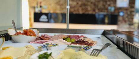 A buffet with various food items including meats, cheeses, and vegetables.