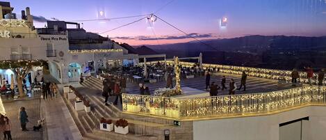 A plaza with outdoor seating and a view of the mountains.
