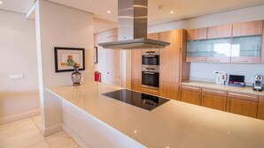 A modern kitchen with a central island, stainless steel appliances, and wooden cabinetry.