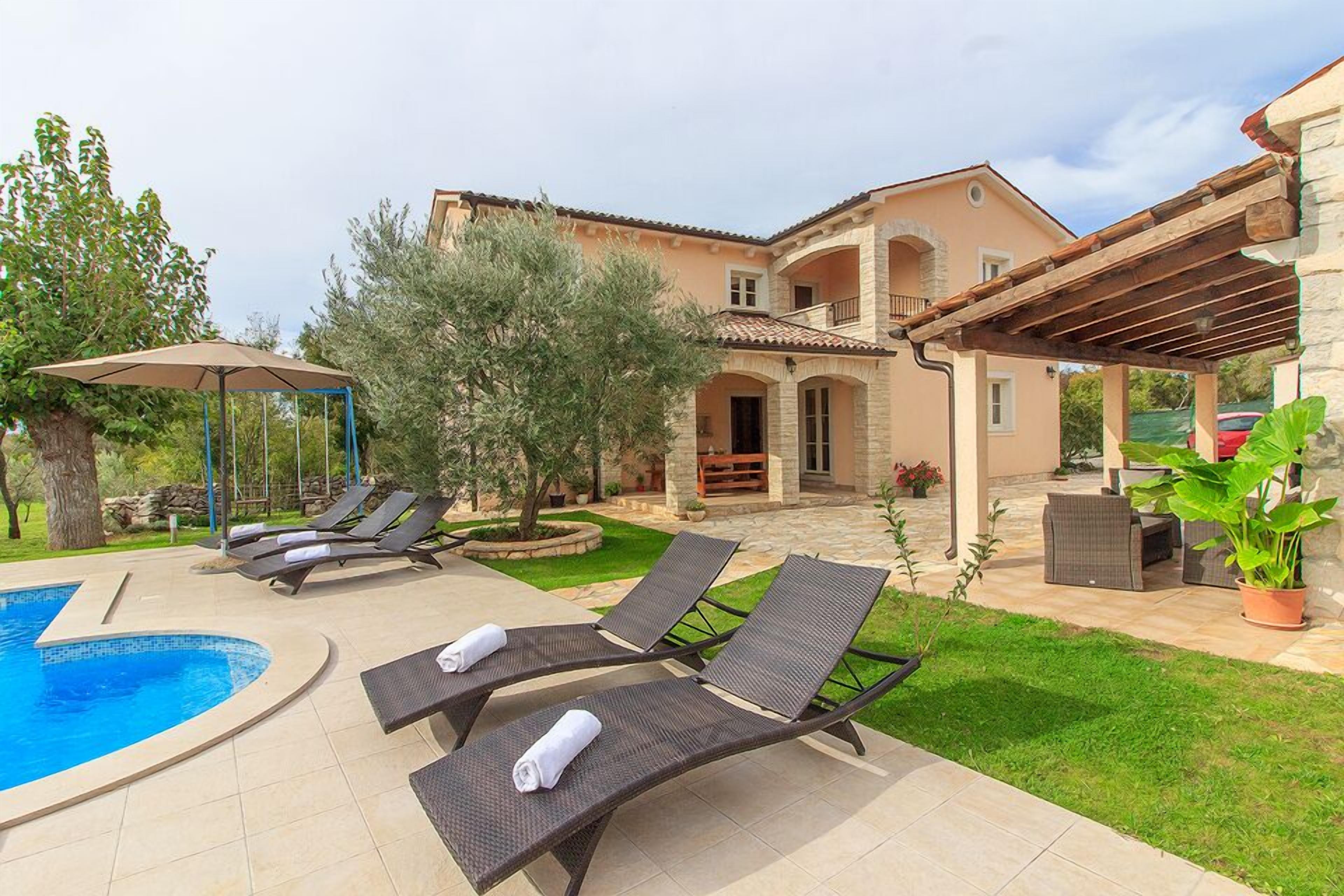 A pool area with lounge chairs and a pergola.