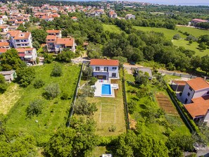 A residential area with houses, a swimming pool, and green spaces.