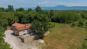 A house with a red-tiled roof, surrounded by a stone wall and a gravel driveway. - Villa Eden (Istria - Labin) (Labin)
