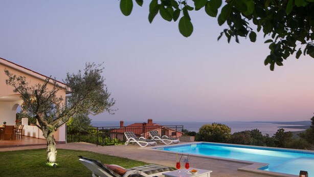 A poolside area with lounge chairs and a table, overlooking a body of water. - Villa MAREVISTA (Istria - Brovinje) (Brovinje)