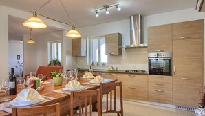 A modern kitchen with wooden cabinets, a stainless steel range hood, and a built-in oven. - Villa MAREVISTA (Istria - Brovinje) (Brovinje)