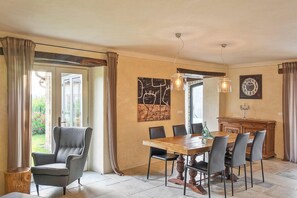 A dining area with a wooden table and chairs, a chandelier, and a view of the outdoors. - Villa Benvenuti (Istria - Motovun) (Motovun)