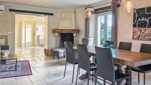Ein Essbereich mit einem Holztisch, schwarzen Stühlen und einer modernen Pendelleuchte.