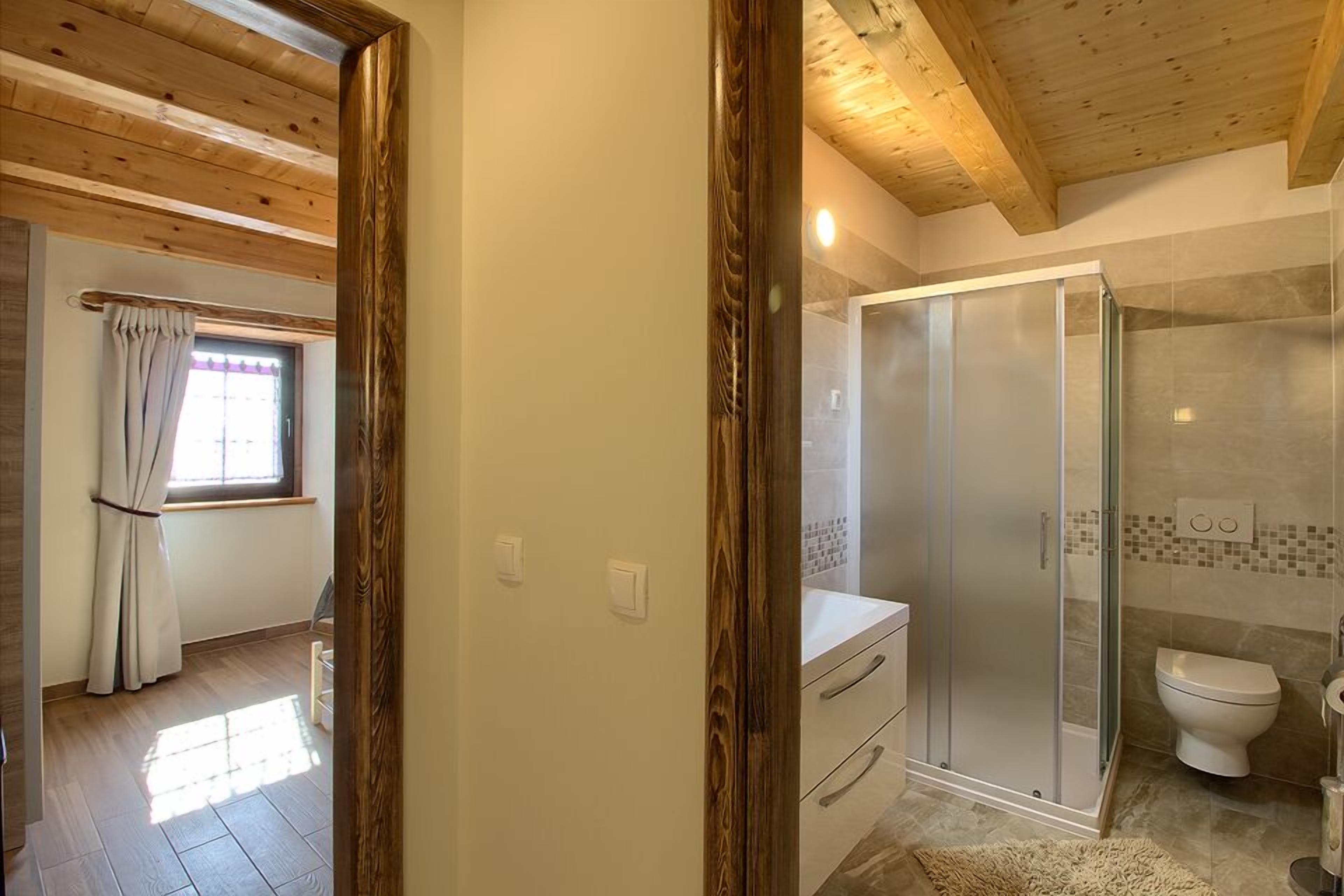 Et moderne badeværelse med en glasbrusekabine, toilet og håndvask.